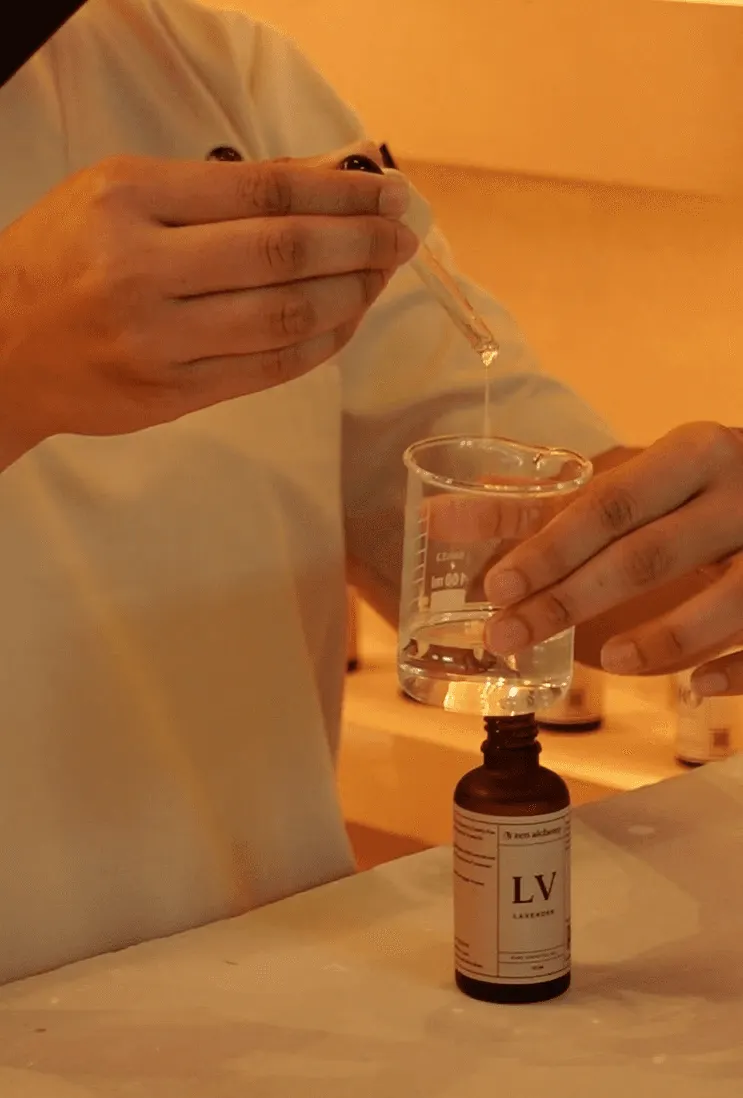 Therapist blending essential oils into a glass