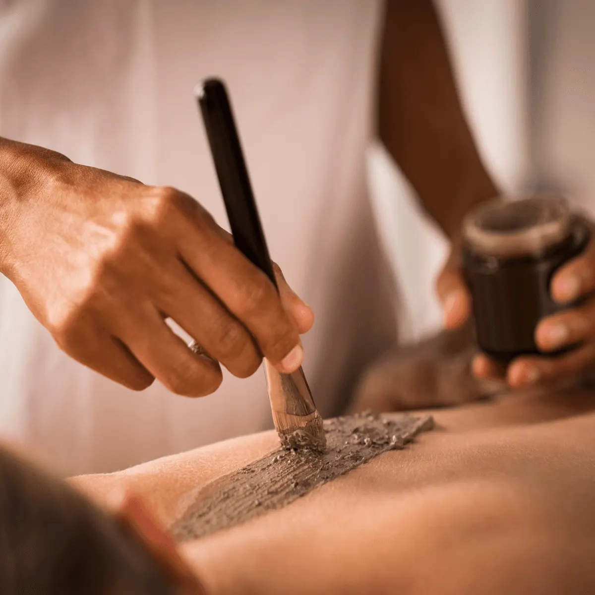 Body scrub being brushed onto a guest's back