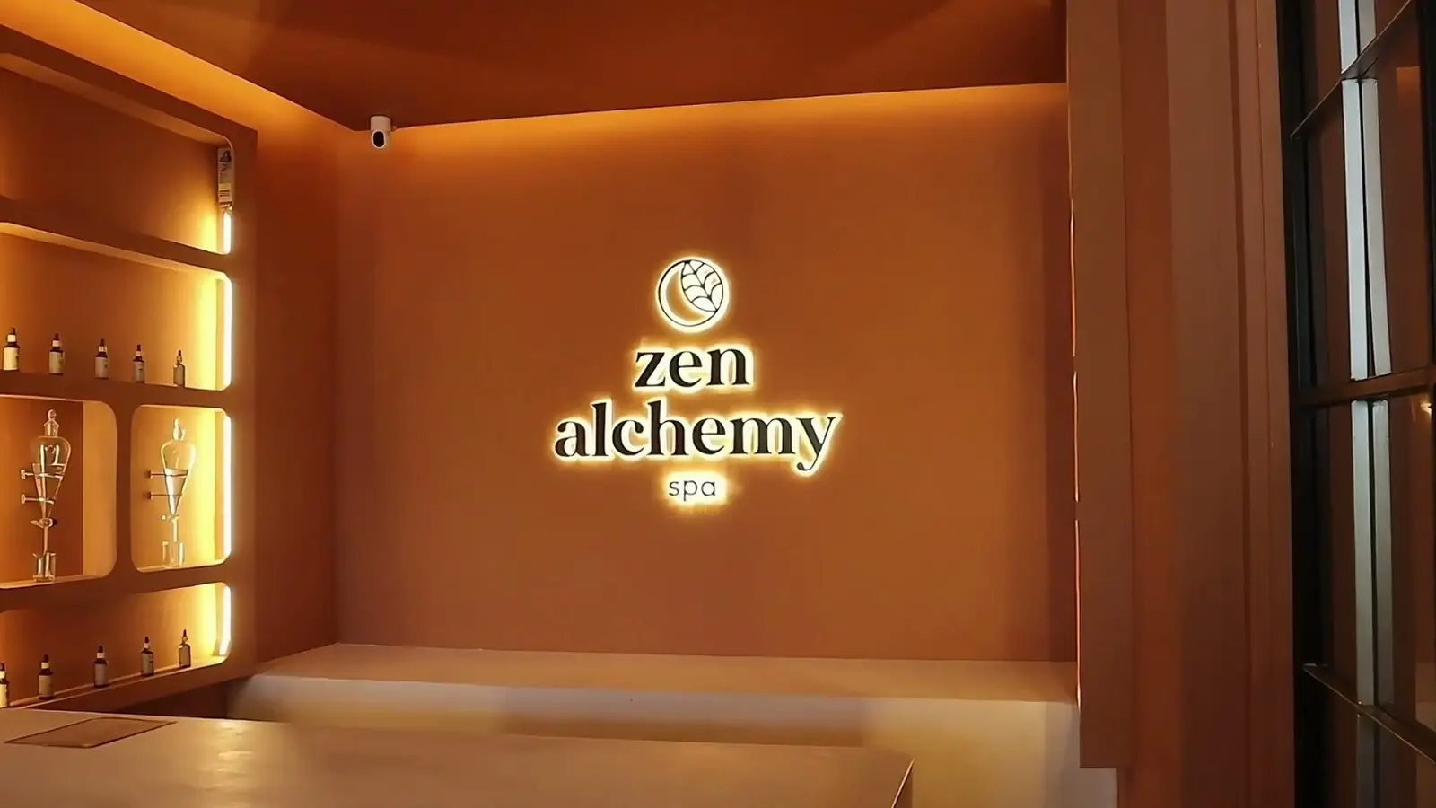 Zen Alchemy Spa treatment room with the illuminated Zen Alchemy logo on the wall
