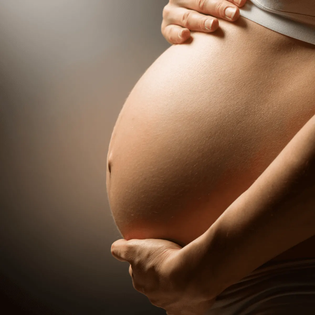 Pregnant woman cradling her belly