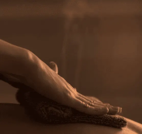 Therapist's hands over a warm towel
